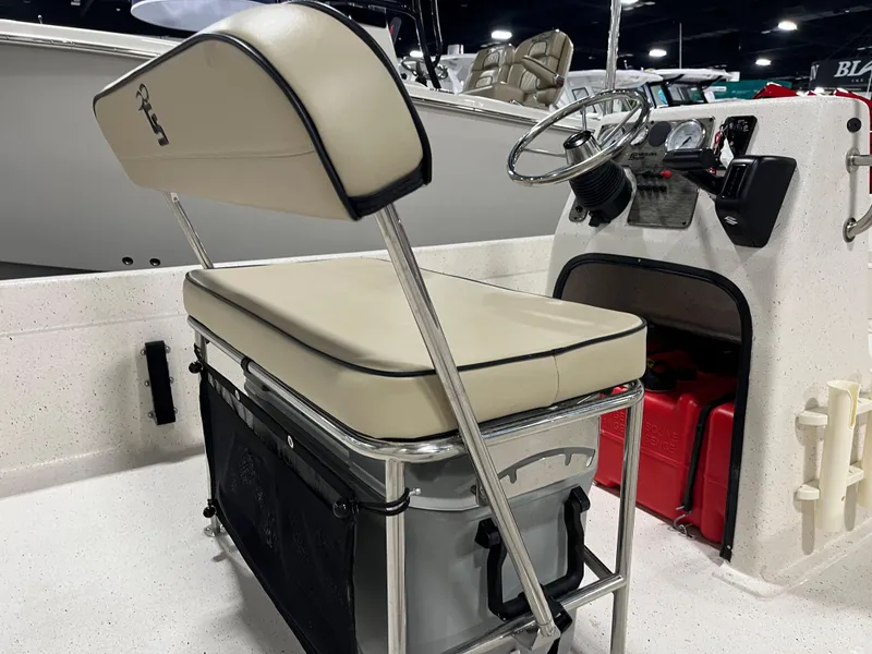 Slide: The Image of 2024 Carolina Skiff e21 DLX boat interior with steering console and cushioned seating. - 6