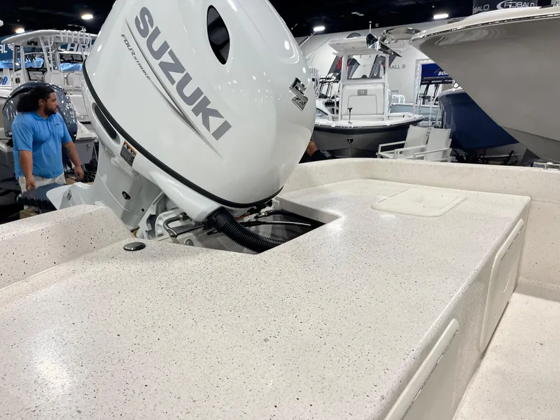 Slide: The Image of 2024 Carolina Skiff e21 DLX with Suzuki outboard motor at a boat show. - 7