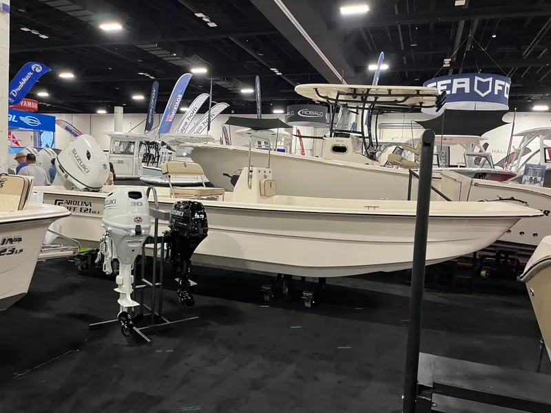 Slide: The Image of 2024 Carolina Skiff e21 DLX boat displayed at an indoor boat show. - 9