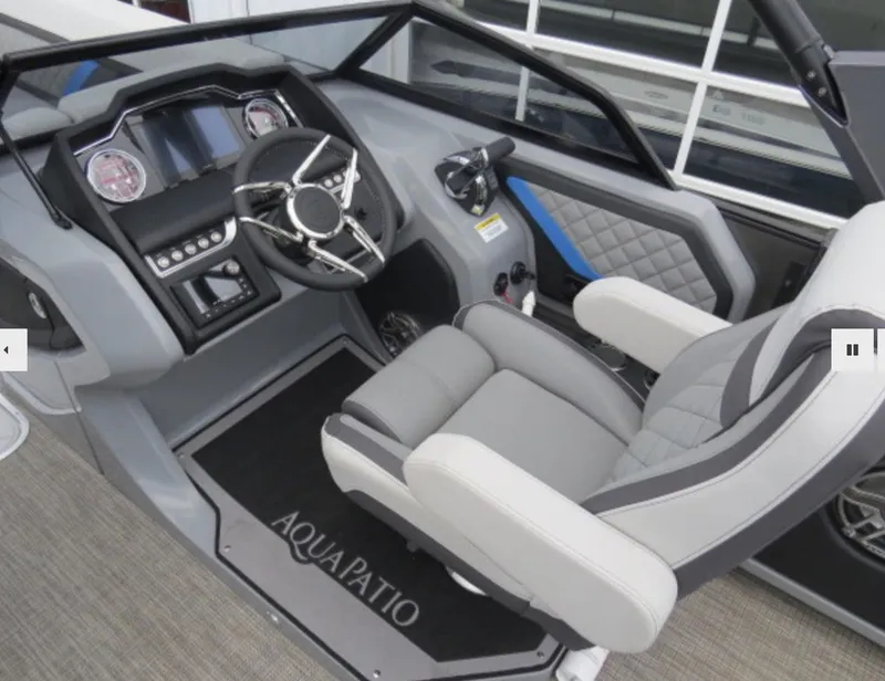 Slide: The Image of 2023 Godfrey AquaPatio 255 DFLW boat cockpit with modern steering wheel and comfortable captain's chair. - 9