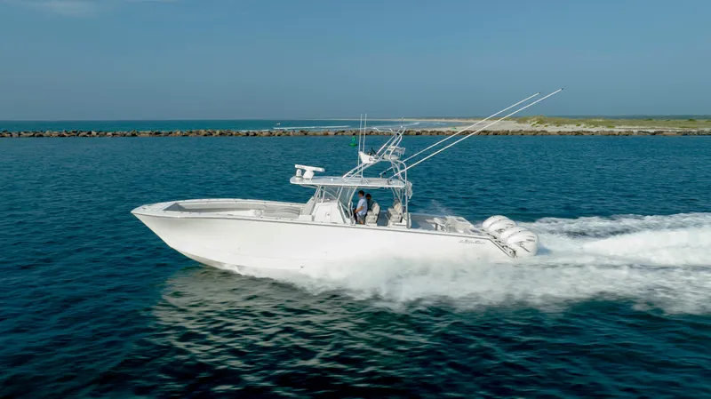 Slide: The Image of 2023 SeaHunter 46 CTS boat cruising on open water, side view. - 10