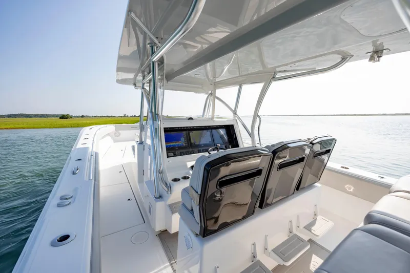 Slide: The Image of 2023 SeaHunter 46 CTS boat interior with sleek seating and modern dashboard on calm water. - 12