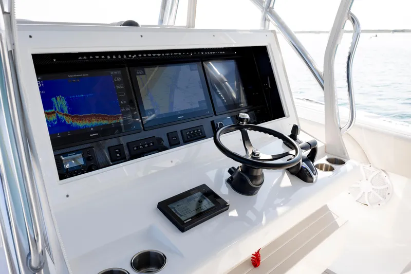 Slide: The Image of 2023 SeaHunter 46 CTS helm with advanced navigation displays and steering wheel. - 15