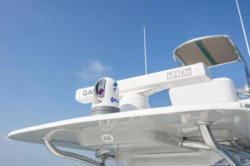 Slide: The Image of 2023 SeaHunter 46 CTS boat with advanced radar and camera equipment under clear blue sky. - 22