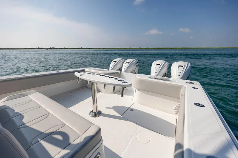 Slide: The Image of 2023 SeaHunter 46 CTS boat with triple engines, spacious deck, and seating on open water. - 27