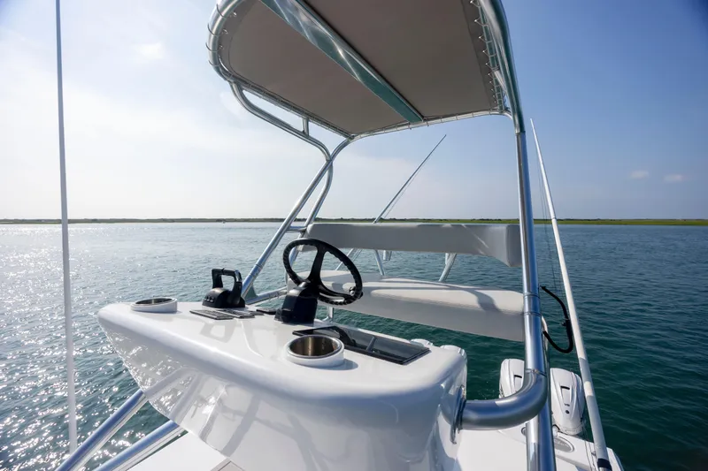 Slide: The Image of 2023 SeaHunter 46 CTS boat helm with canopy on calm water. - 34