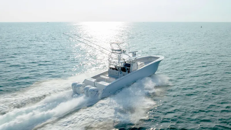 Slide: The Image of 2023 SeaHunter 46 CTS boat cruising on open water under bright sunlight. - 38