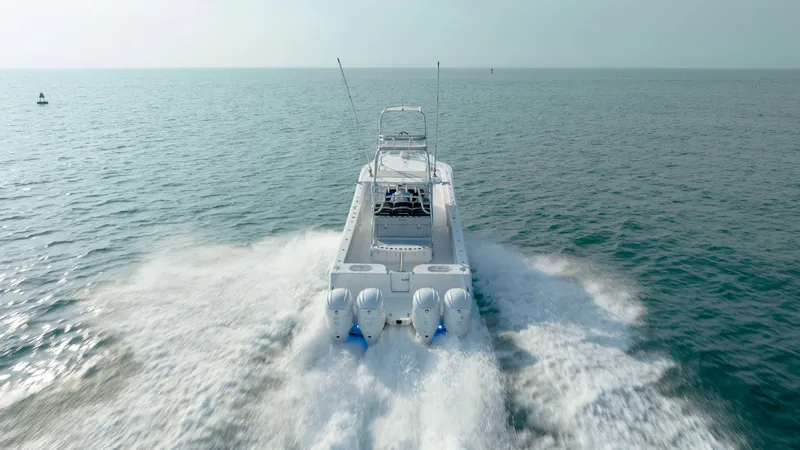 Slide: The Image of 2023 SeaHunter 46 CTS boat cruising on open water, rear view. - 39