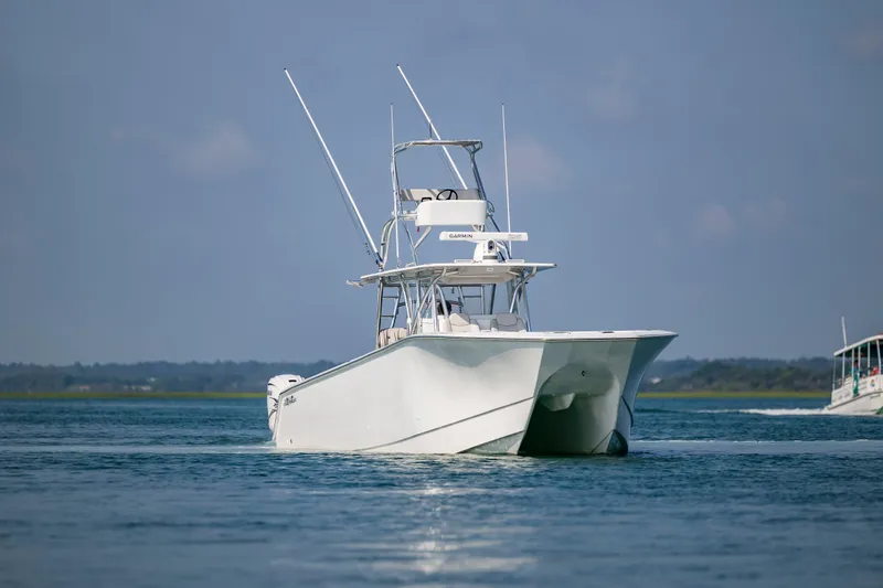 Slide: The Image of 2023 SeaHunter 46 CTS catamaran cruising on calm waters under a clear blue sky. - 4