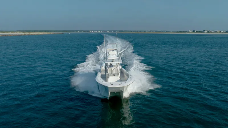 Slide: The Image of 2023 SeaHunter 46 CTS boat cruising on open water, creating a dynamic wake. - 45