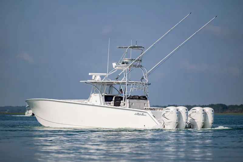 Slide: The Image of 2023 SeaHunter 46 CTS boat cruising on calm waters, featuring multiple outboard engines. - 5