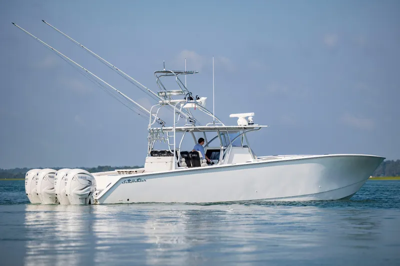 Slide: The Image of 2023 SeaHunter 46 CTS boat on calm water, featuring triple outboard engines. - 6