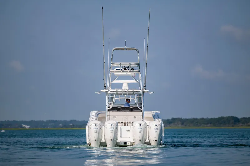 Slide: The Image of 2023 SeaHunter 46 CTS boat cruising on open water, rear view. - 7