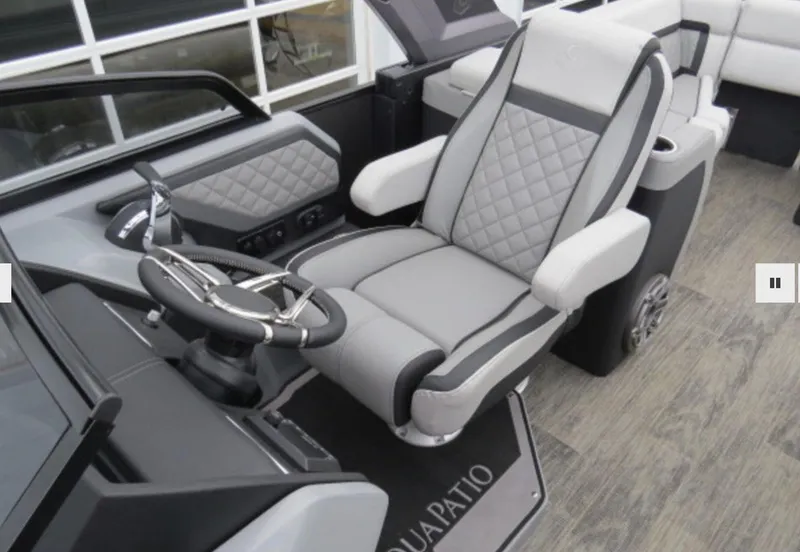 Slide: The Image of 2023 Godfrey AquaPatio 255 ULW boat interior with captain's chair and steering wheel. - 13