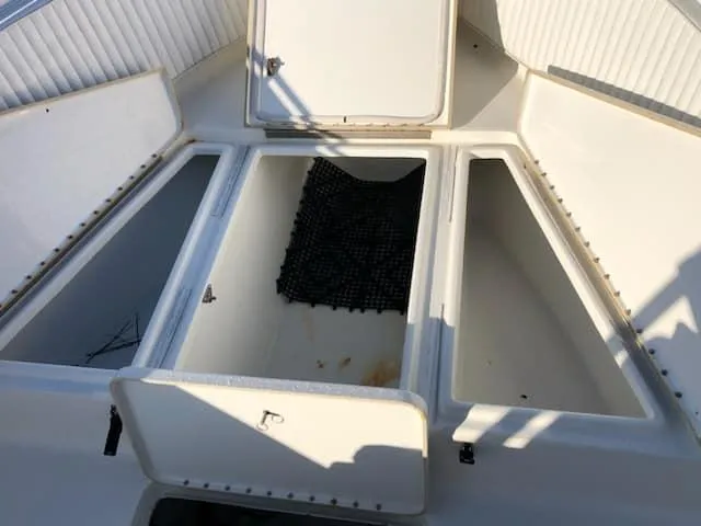 Slide: The Image of 2004 Triton 2690 CC boat storage compartments open. - 4