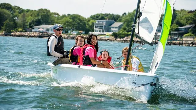 Slide: The Image of Group sailing on RS Quest 2025 boat in sunny coastal waters. - 1