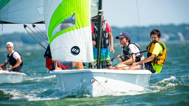 Slide: The Image of Sailors navigating an RS Quest 2025 boat on a sunny day. - 2