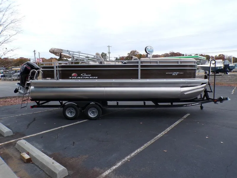 Slide: The Image of 2024 Sun Tracker SportFish™ 22 DLX pontoon boat on a trailer in a parking lot. - 7