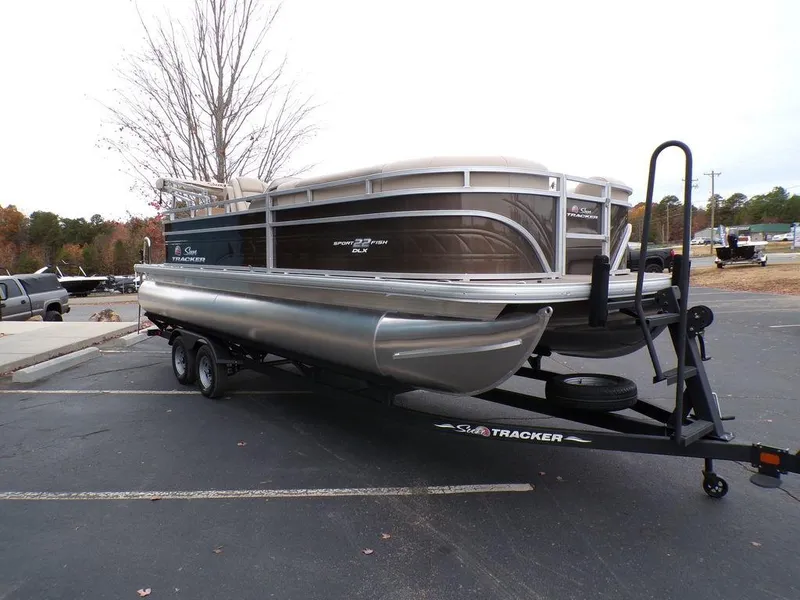 Slide: The Image of 2024 Sun Tracker SportFish™ 22 DLX pontoon boat on trailer in parking lot. - 9