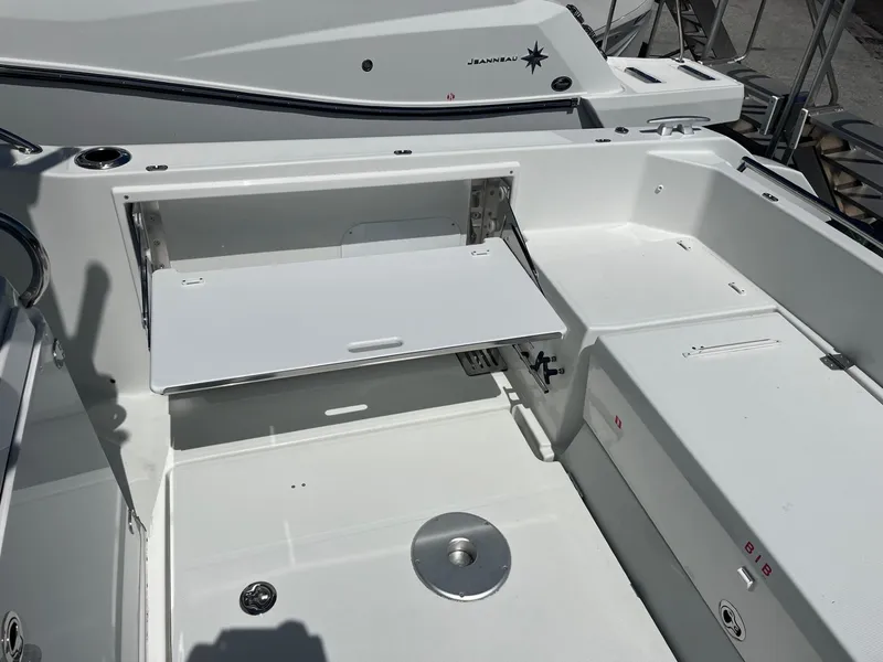 Slide: The Image of 2024 Jeanneau Leader 9.0 CC boat interior with foldable table and seating area. - 11