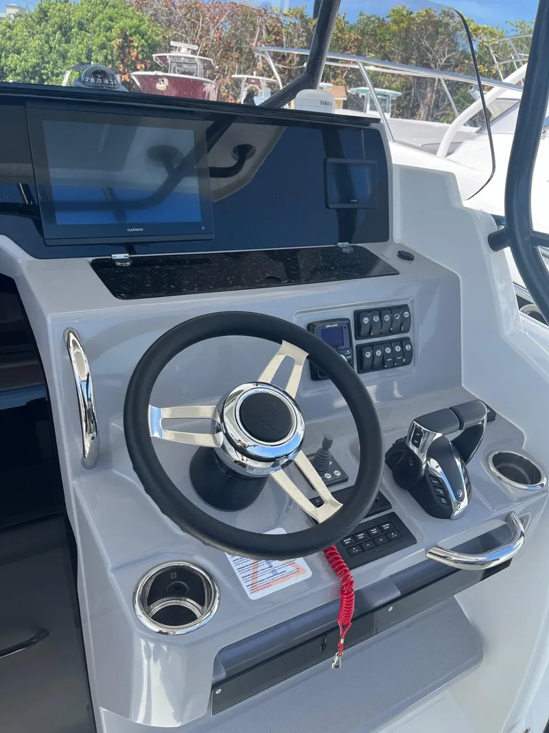 Slide: The Image of 2024 Jeanneau Leader 9.0 CC helm station with modern controls and steering wheel. - 7