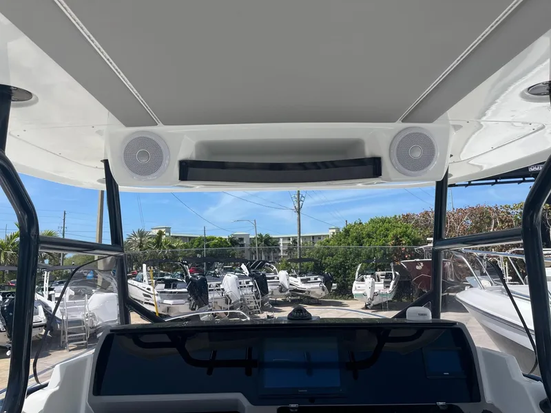 Slide: The Image of 2024 Jeanneau Leader 9.0 CC helm station with overhead speakers and navigation equipment. - 8