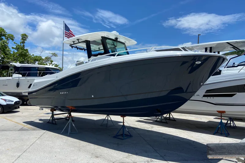The Image of 2027 Jeanneau Leader 9.0 CC boat on stands, displayed outdoors under a clear sky. - 0