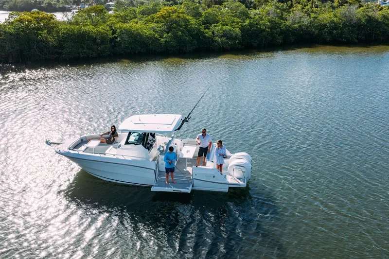 Slide: The Image of 2027 Jeanneau Leader 9.0 CC boat cruising on a serene lake with passengers. - 17