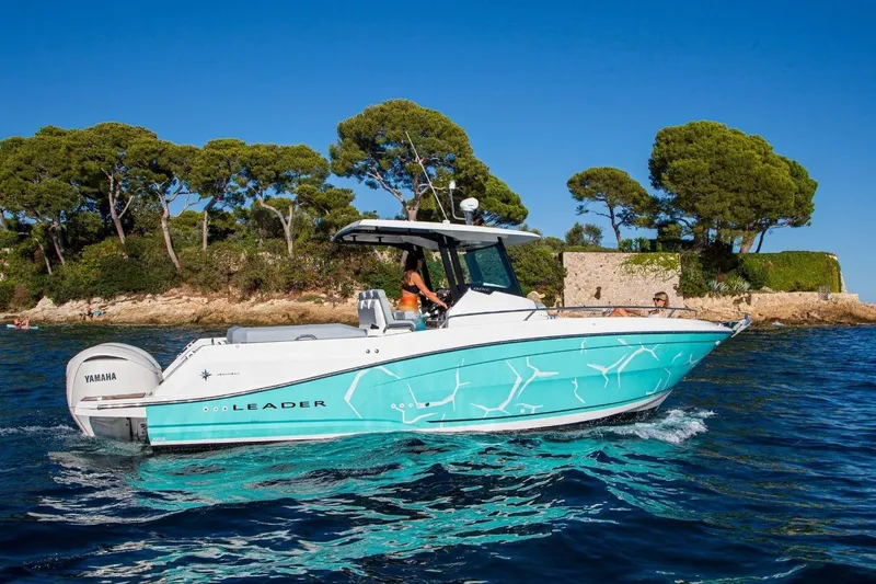 Slide: The Image of 2027 Jeanneau Leader 9.0 CC boat cruising near a scenic coastline with trees. - 20