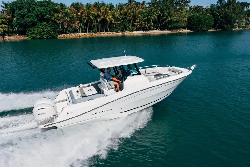 Slide: The Image of 2027 Jeanneau Leader 9.0 CC cruising on a tropical waterway with lush greenery. - 4