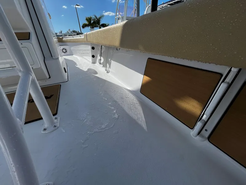 Slide: The Image of 2024 Sportsman Masters 247OE Bay Boat interior deck view with seating and storage compartments. - 12