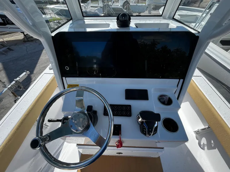 Slide: The Image of 2024 Sportsman Masters 247OE Bay Boat helm station with steering wheel and controls. - 9