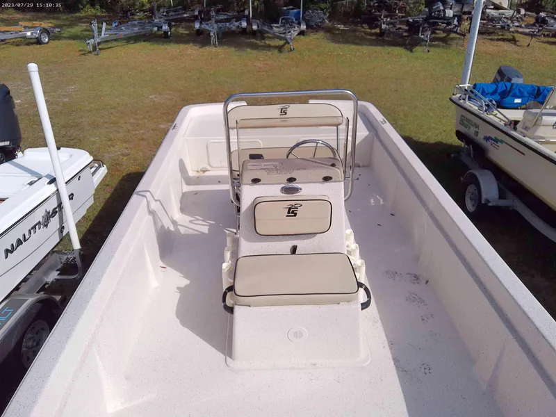 Slide: The Image of 2024 Carolina Skiff e21 DLX boat interior with beige seating and steering console. - 3