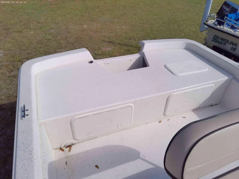 Slide: The Image of 2024 Carolina Skiff e21 DLX boat interior with storage compartments and seating. - 4