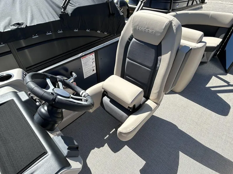 Slide: The Image of 2024 Harris Cruiser 230 boat interior with steering wheel and captain's chair. - 10