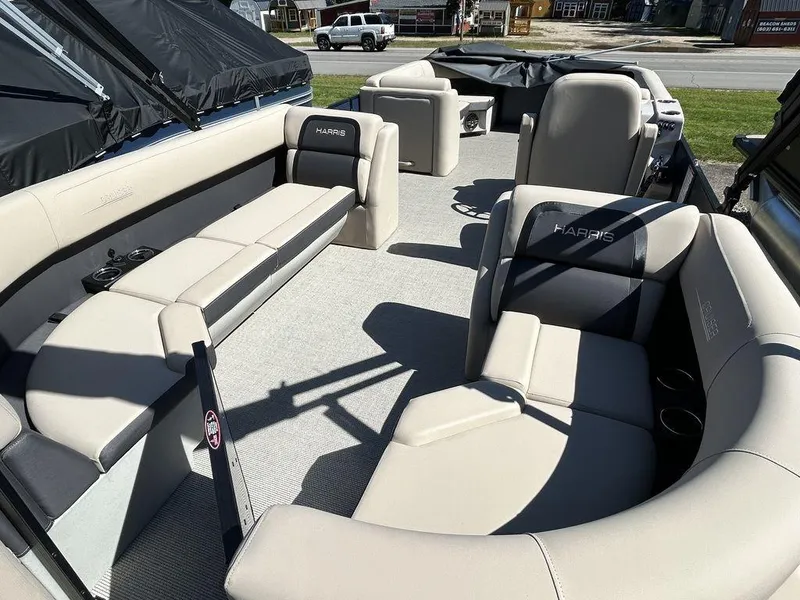 Slide: The Image of 2024 Harris Cruiser 230 pontoon boat interior with beige seating and black accents. - 12