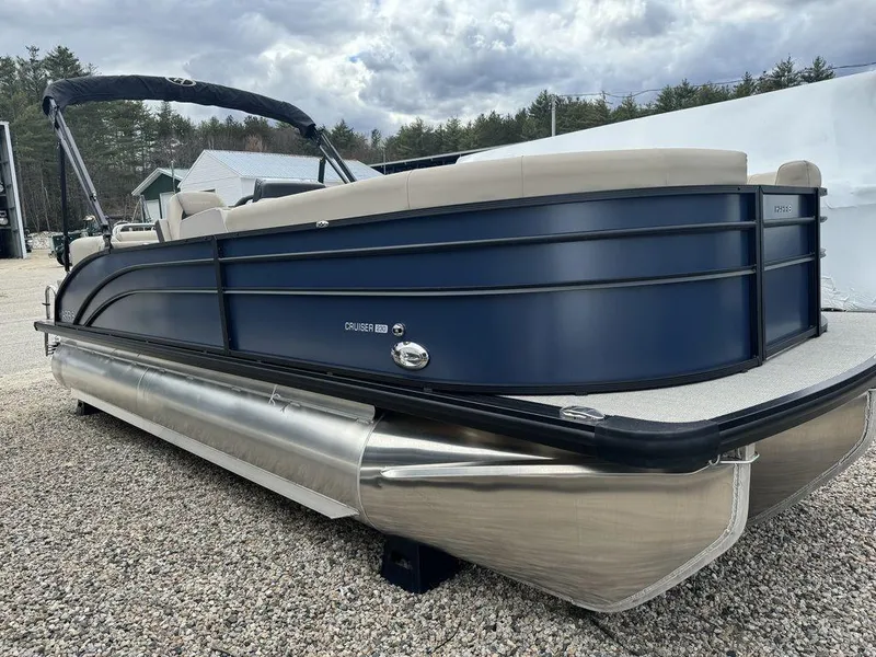 Slide: The Image of 2024 Harris Cruiser 230 pontoon boat with sleek design on gravel surface. - 3