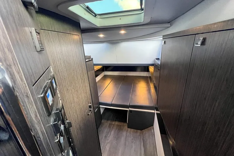 Slide: The Image of 2024 Mystic Powerboats M5200 interior cabin with modern design and skylight. - 5