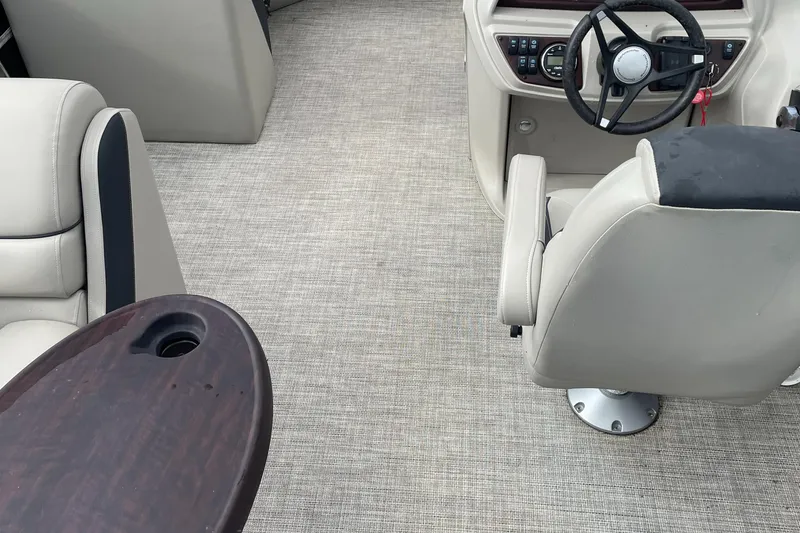 Slide: The Image of 2022 Berkshire 22CL2LE25 boat interior with beige seating and steering console. - 2