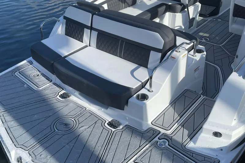 Slide: The Image of 2024 Monterey M4 boat with black and white seating on the water. - 10