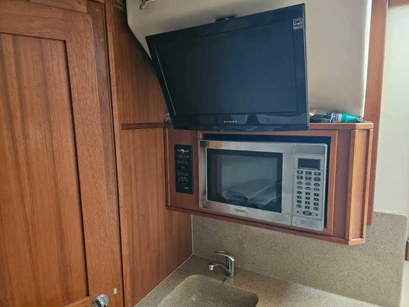 Slide: The Image of 2008 Albemarle 31 interior with TV, microwave, and wooden cabinetry. - 19