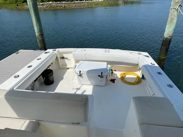 Slide: The Image of 2008 Albemarle 31 boat deck with seating, cooler, and coiled hose by the water. - 26