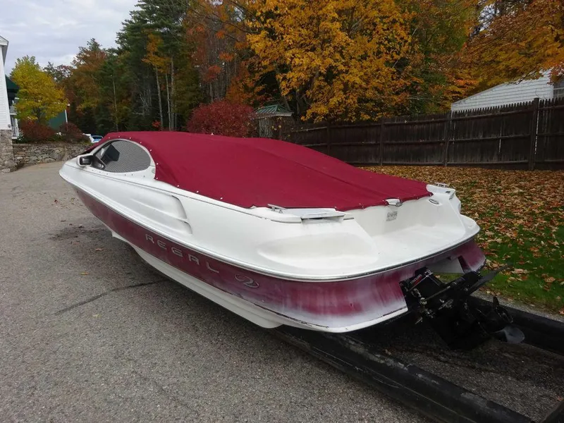 Slide: The Image of 2000 Regal 2100 LSR boat with red cover, parked on a street in autumn. - 14