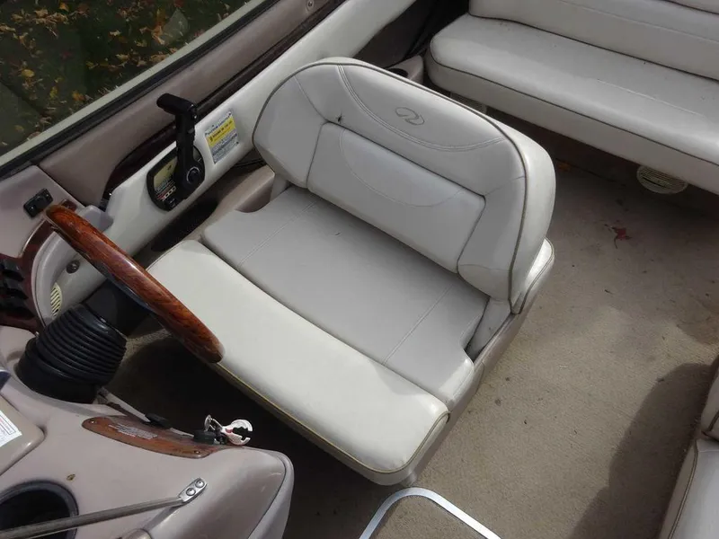 Slide: The Image of Interior of a 2000 Regal 2100 LSR boat with beige seating and wooden steering wheel. - 16