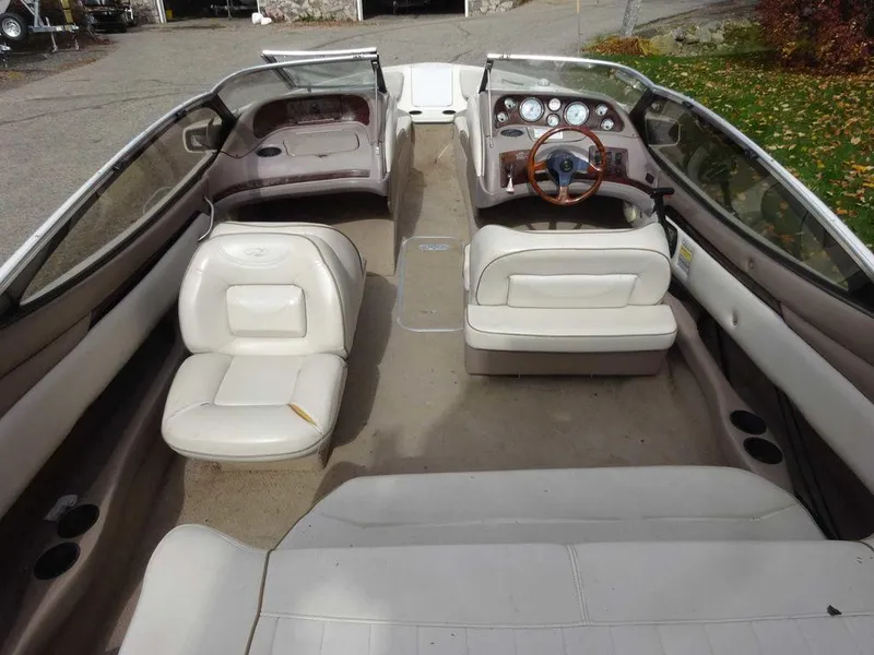 Slide: The Image of 2000 Regal 2100 LSR boat interior with white seating and wooden steering wheel. - 3