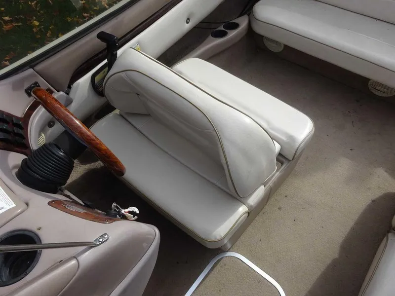 Slide: The Image of Interior of a 2000 Regal 2100 LSR boat with white seating and wooden steering wheel. - 6