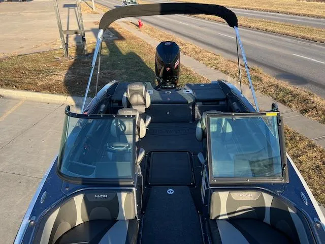 Slide: The Image of 2024 Lund 189 Tyee GL boat with open cockpit and bimini top on a sunny day. - 10