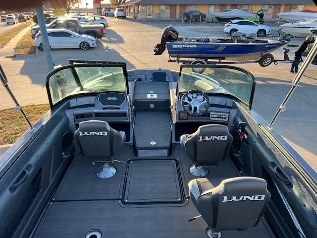 Slide: The Image of 2024 Lund 189 Tyee GL boat interior with seating and dashboard view. - 11