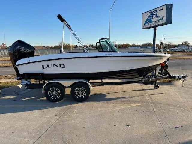 Slide: The Image of 2024 Lund 189 Tyee GL boat on trailer, parked outdoors near a sign. - 7