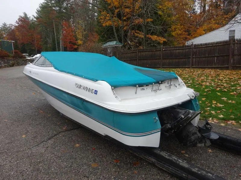 Slide: The Image of 1998 Four Winns 200 Horizon boat with teal cover on a trailer. - 2